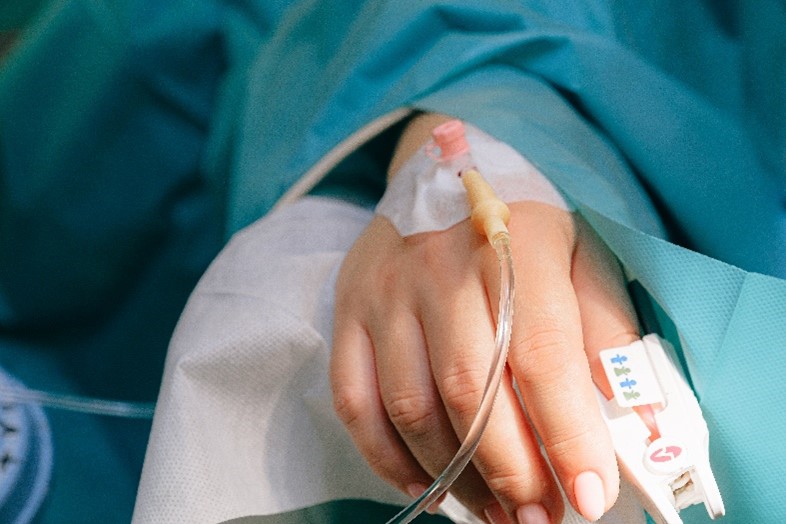 Image of a person's hand in hospital with a medical cannula