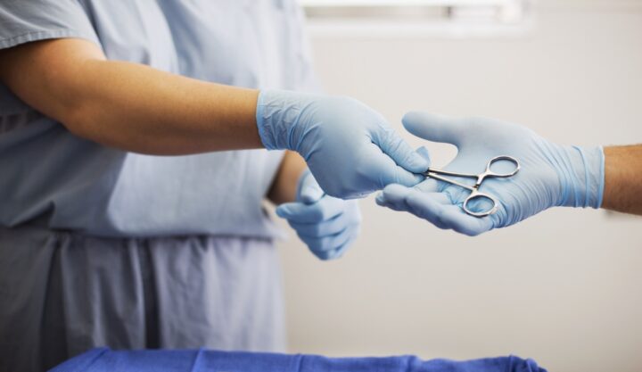 Assistant passing surgical tools to surgeon