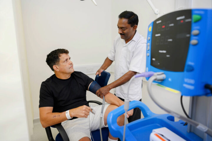 Nurse with a patient checking their blood pressure.