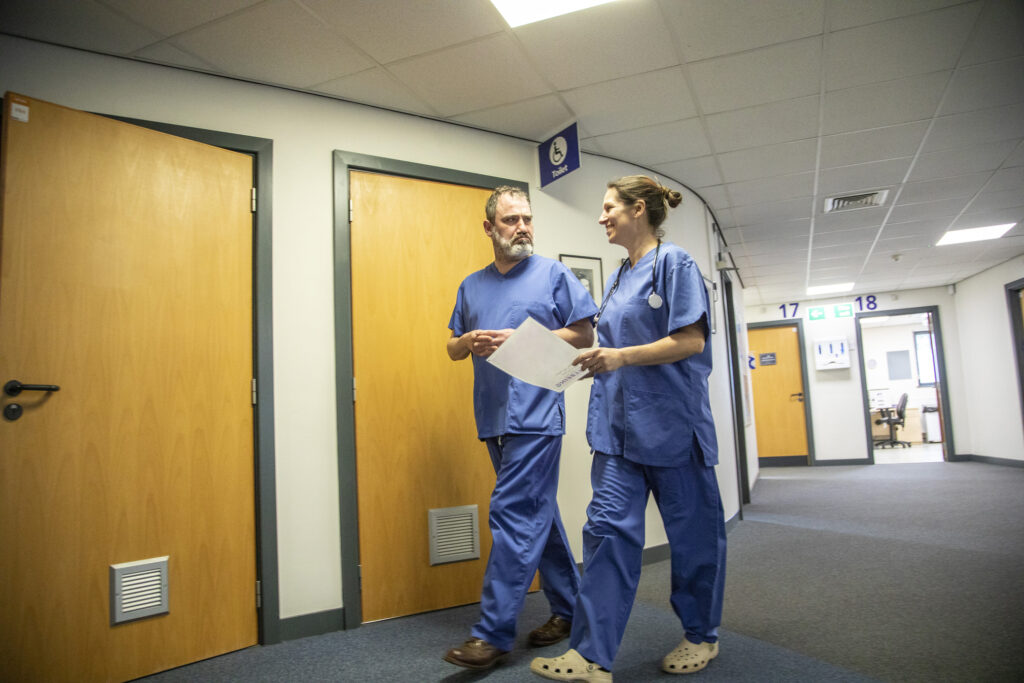 Medical Staff Walking Through A Hospital Corridor, UK