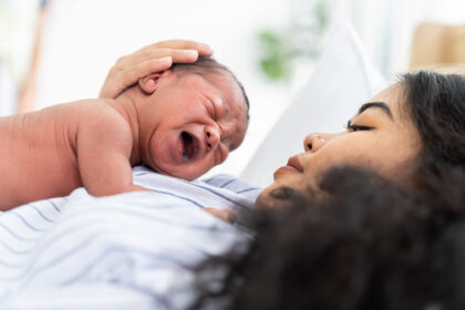 New mother holding her newborn baby in a hospital setting
