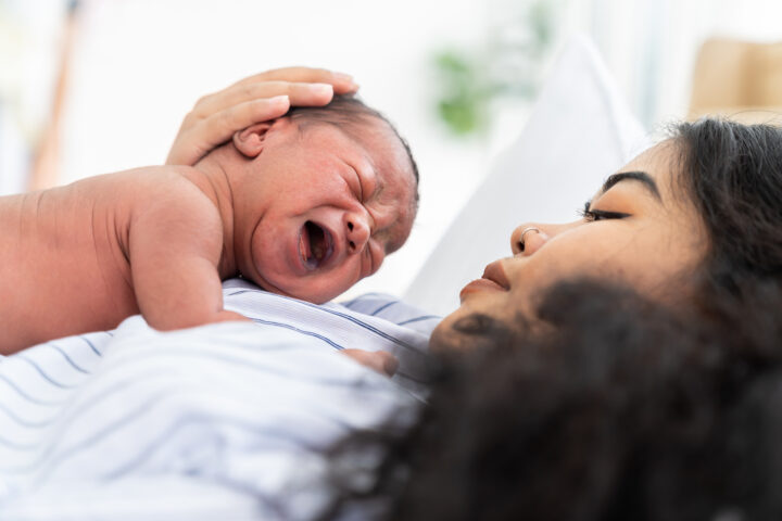 New mother holding her newborn baby in a hospital setting